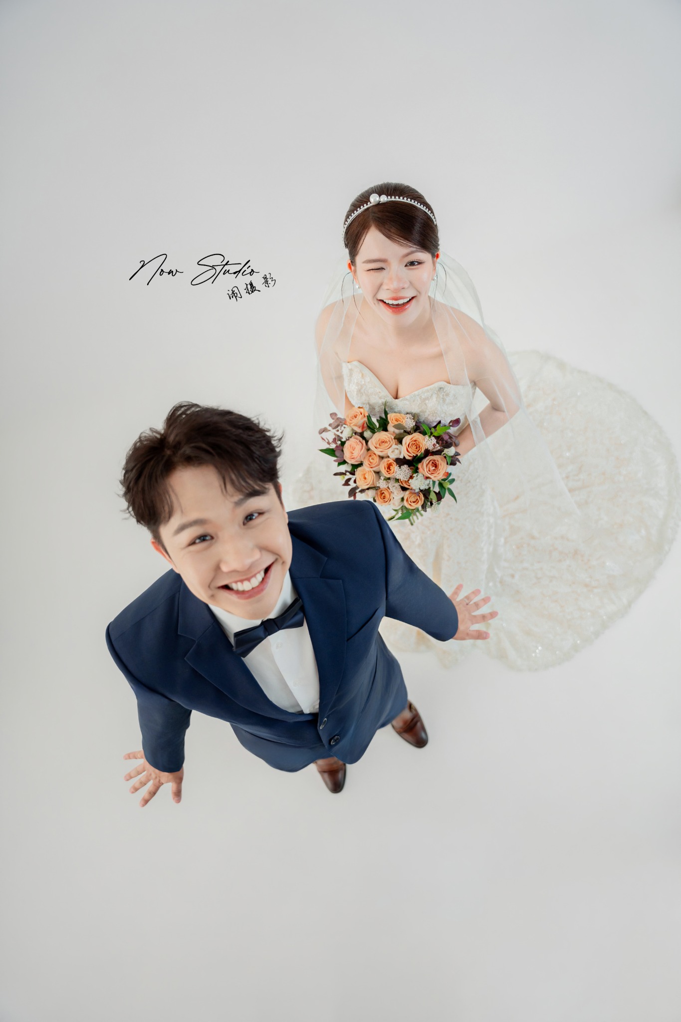A joyful bride and groom looking up at the camera